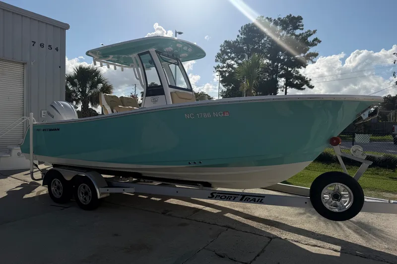 Slide: The Image of 2025 Sportsman Heritage 231 Center Console boat on trailer, parked outdoors. - 6