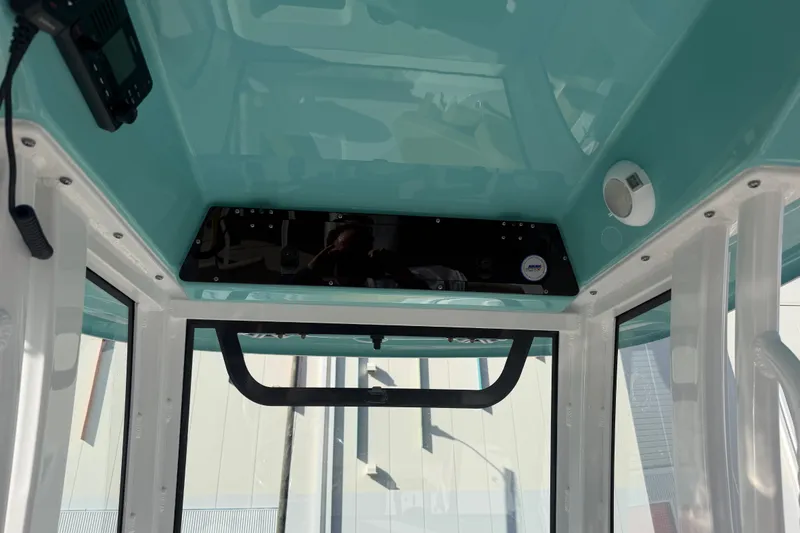 Slide: The Image of Interior view of 2025 Sportsman Heritage 231 Center Console boat, featuring teal ceiling and modern controls. - 33