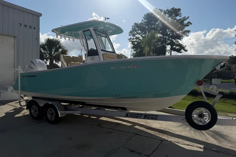 Slide: The Image of 2025 Sportsman Heritage 231 Center Console boat on trailer, parked outdoors. - 7