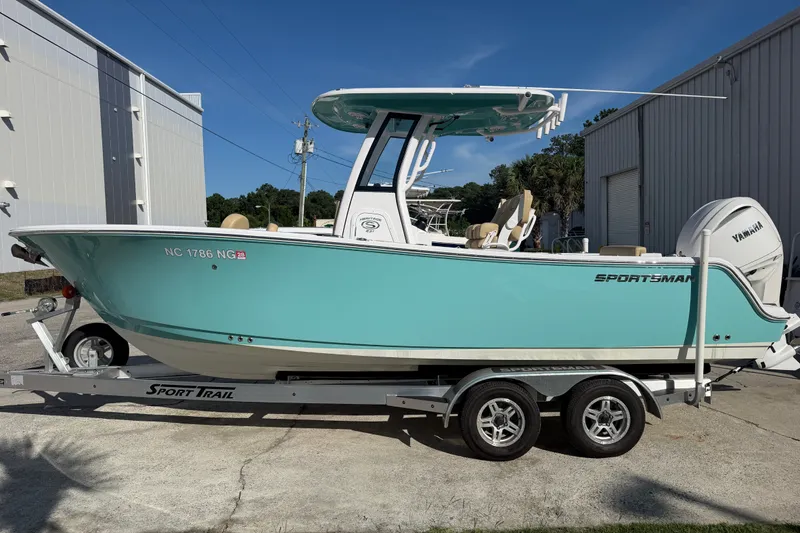 Slide: The Image of 2025 Sportsman Heritage 231 Center Console boat on trailer, turquoise hull, parked outdoors. - 1