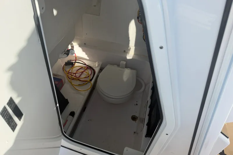 Slide: The Image of Interior view of 2025 Sportsman Heritage 231 Center Console boat's compact restroom. - 32
