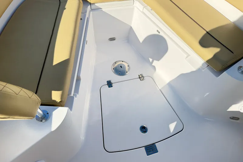 Slide: The Image of 2025 Sportsman Heritage 231 Center Console boat interior with beige seating and storage hatch. - 38