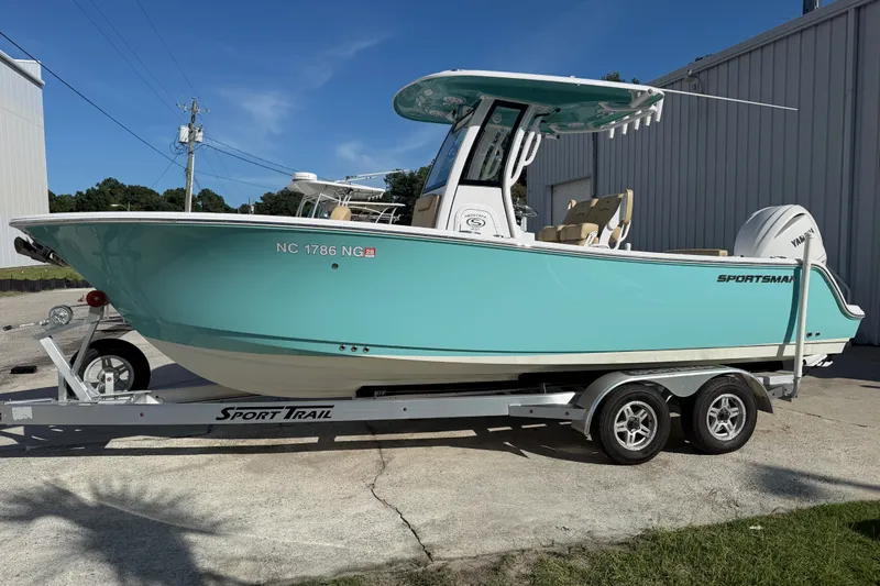 Slide: The Image of 2025 Sportsman Heritage 231 Center Console boat on trailer, turquoise hull, parked outdoors. - 3