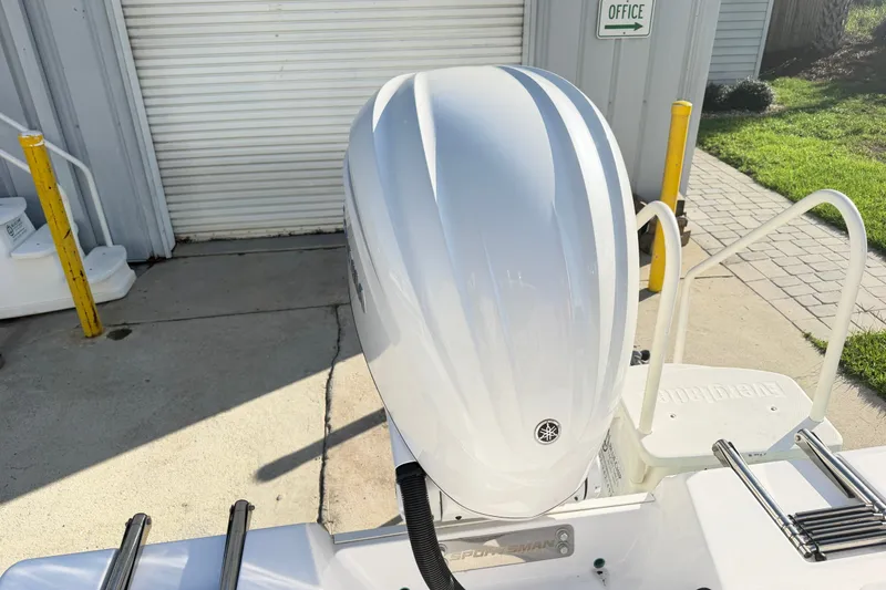 Slide: The Image of 2025 Sportsman Heritage 231 Center Console boat engine, parked near a garage. - 42