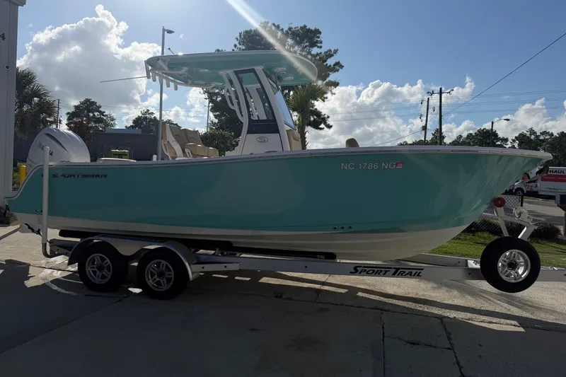 Slide: The Image of 2025 Sportsman Heritage 231 Center Console boat on trailer, parked outdoors under a sunny sky. - 8