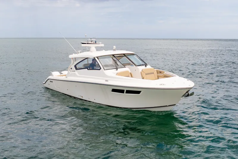 Slide: The Image of 2018 Pursuit DC 365 Dual Console boat cruising on open water. - 14
