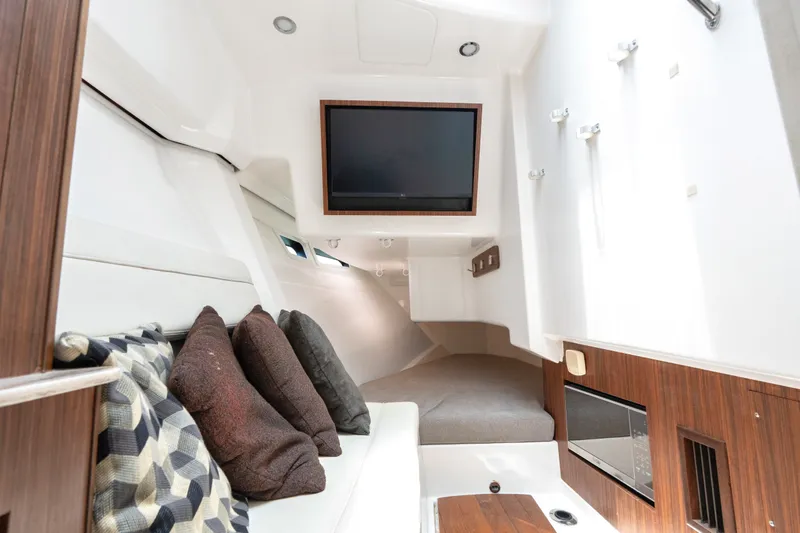 Slide: The Image of Interior of 2018 Pursuit DC 365 Dual Console boat with cozy seating and TV. - 54