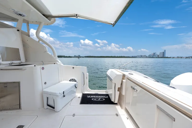 Slide: The Image of 2018 Pursuit DC 365 Dual Console boat with ocean view and city skyline. - 25