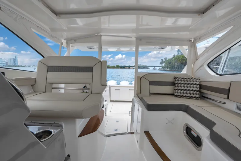 Slide: The Image of 2018 Pursuit DC 365 Dual Console interior with seating, overlooking scenic waterfront. - 38