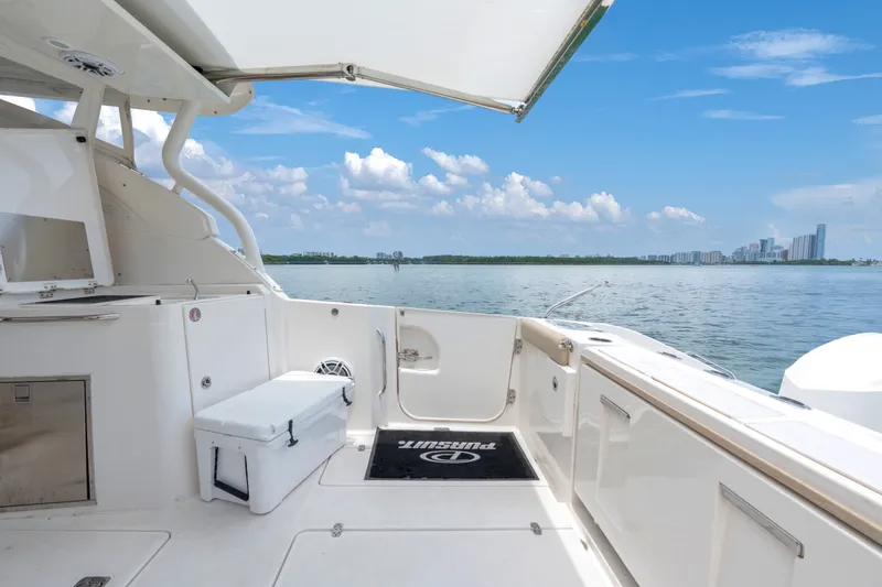 Slide: The Image of 2018 Pursuit DC 365 Dual Console boat interior with ocean view and city skyline. - 27