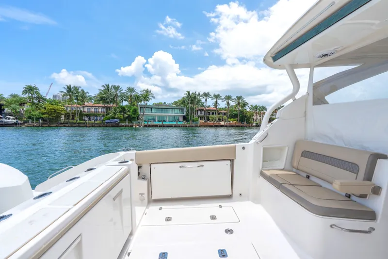 Slide: The Image of 2018 Pursuit DC 365 Dual Console boat interior with waterfront view and luxurious seating. - 29