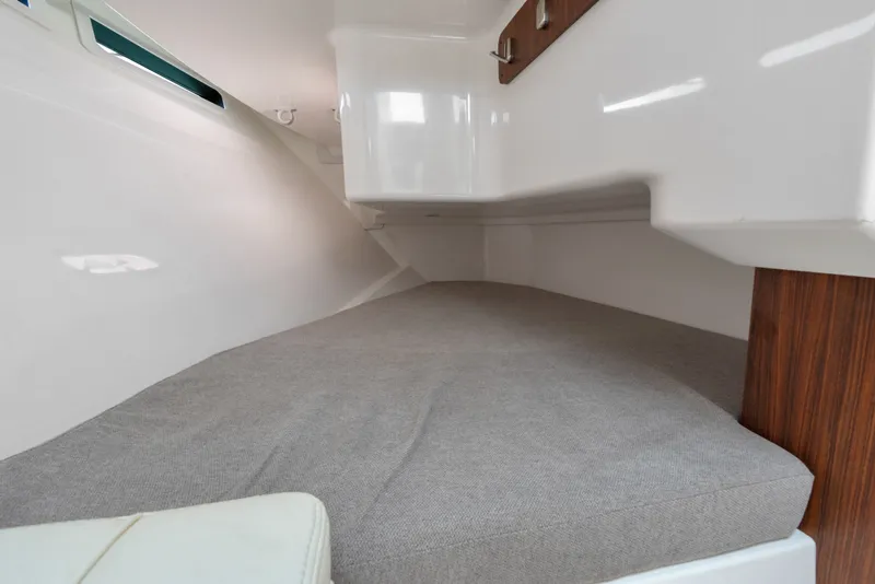 Slide: The Image of 2018 Pursuit DC 365 Dual Console cabin interior with cushioned seating and wooden accents. - 53