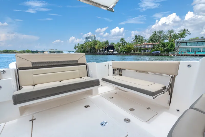 Slide: The Image of 2018 Pursuit DC 365 Dual Console boat interior with seating, overlooking scenic waterfront homes. - 23