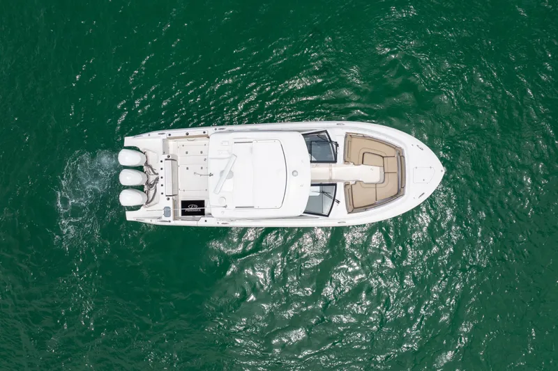 Slide: The Image of Overhead view of 2018 Pursuit DC 365 Dual Console boat on green water. - 20