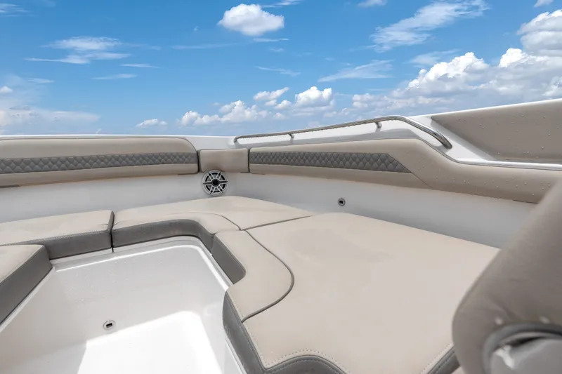 Slide: The Image of 2018 Pursuit DC 365 Dual Console boat interior with cushioned seating under a blue sky. - 35