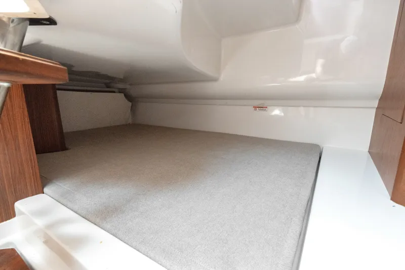 Slide: The Image of Interior cabin of 2018 Pursuit DC 365 Dual Console boat, featuring a cushioned sleeping area. - 59