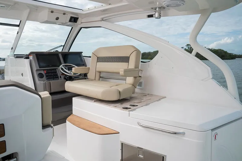Slide: The Image of Manufacturer Provided Image: 2018 Pursuit DC 365 Dual Console boat interior with captain's chair and control panel. - 50