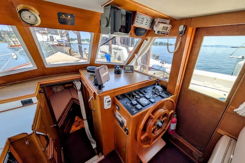 Slide: The Image of Interior helm of 1987 Island Gypsy 32 boat with wooden steering wheel and navigation equipment. - 8