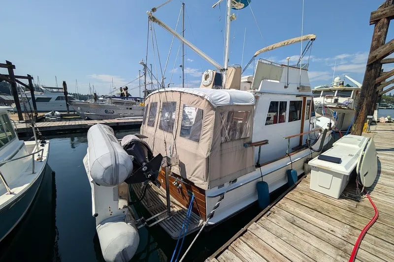 Slide: The Image of 1987 Island Gypsy 32 yacht docked at marina with inflatable dinghy attached. - 34