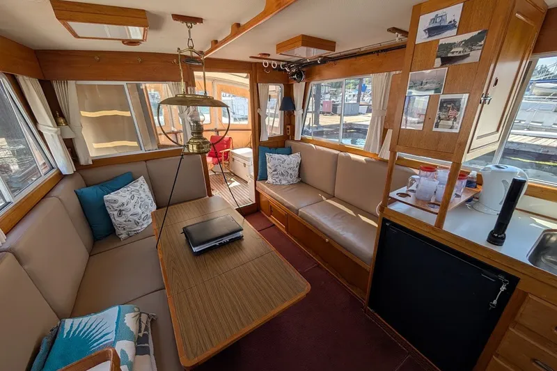 Slide: The Image of Interior of 1987 Island Gypsy 32 yacht with cozy seating and nautical decor. - 6