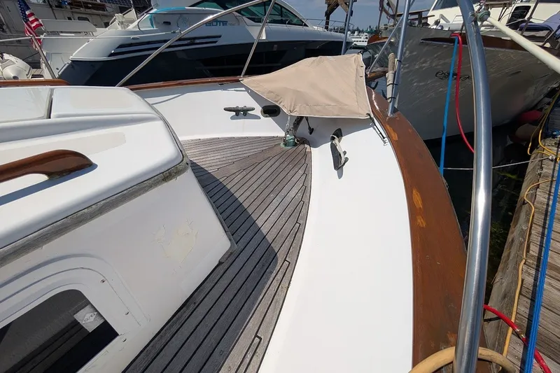 Slide: The Image of 1987 Island Gypsy 32 boat deck with wooden trim, docked at marina. - 31