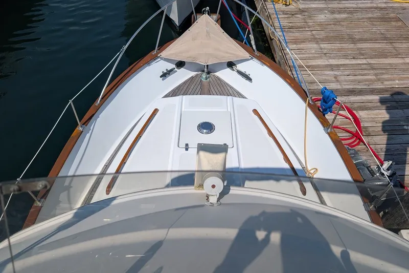 Slide: The Image of 1987 Island Gypsy 32 boat docked, showcasing deck details and mooring lines. - 27