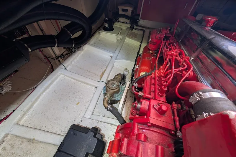 Slide: The Image of Engine compartment of a 1987 Island Gypsy 32 boat, featuring red mechanical components. - 39