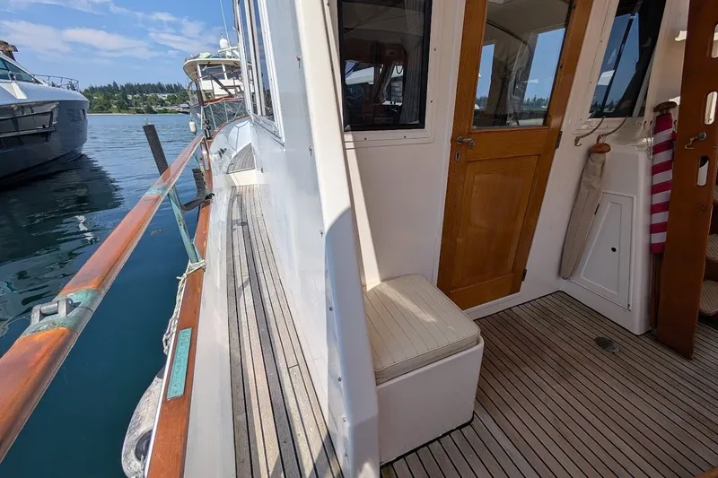 Slide: The Image of 1987 Island Gypsy 32 boat deck with wooden railings and cabin entrance. - 23