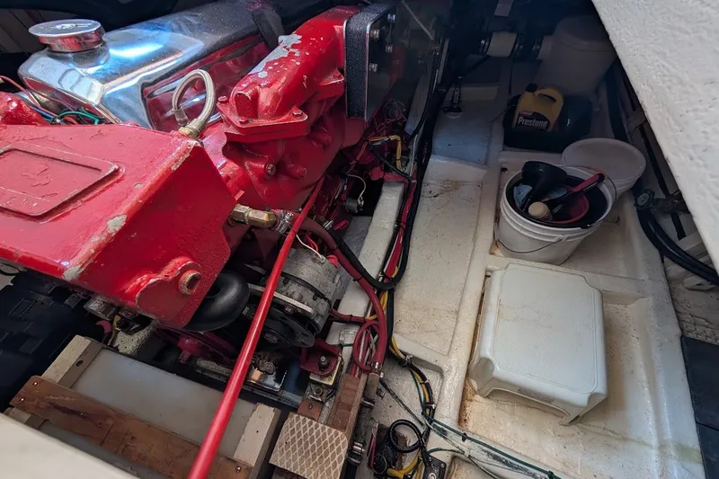 Slide: The Image of Engine compartment of a 1987 Island Gypsy 32 boat with red engine and maintenance tools. - 37