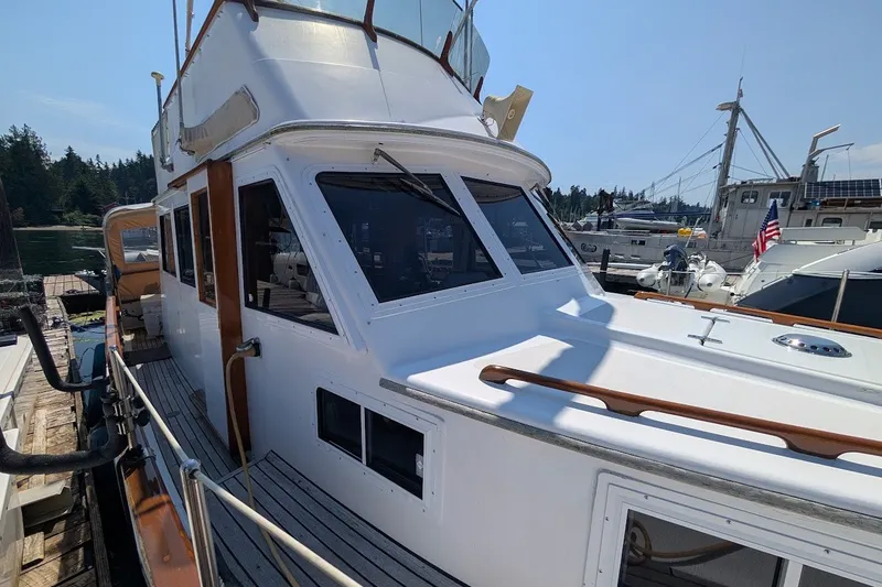 Slide: The Image of 1987 Island Gypsy 32 yacht docked at marina, featuring classic design and wooden accents. - 3
