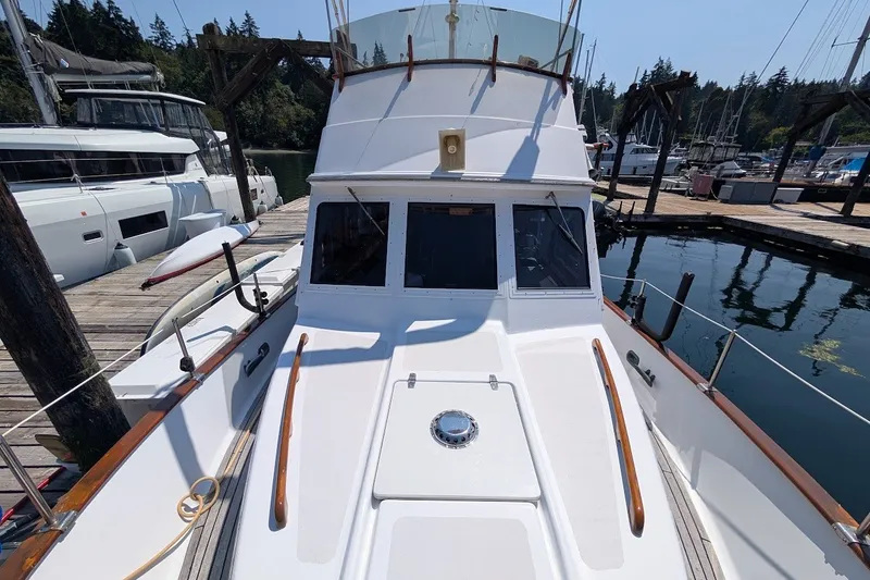 Slide: The Image of 1987 Island Gypsy 32 yacht docked at marina, showcasing deck and cabin. - 5