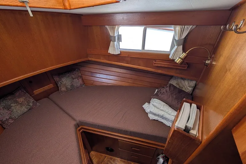 Slide: The Image of Cozy cabin interior of 1987 Island Gypsy 32 with wood paneling and comfortable bedding. - 13