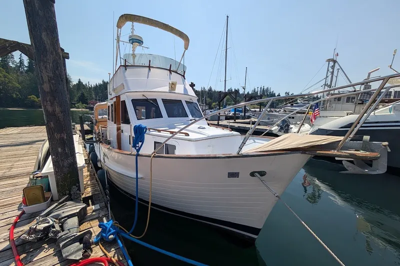 Slide: The Image of 1987 Island Gypsy 32 boat docked at marina, surrounded by other vessels. - 1