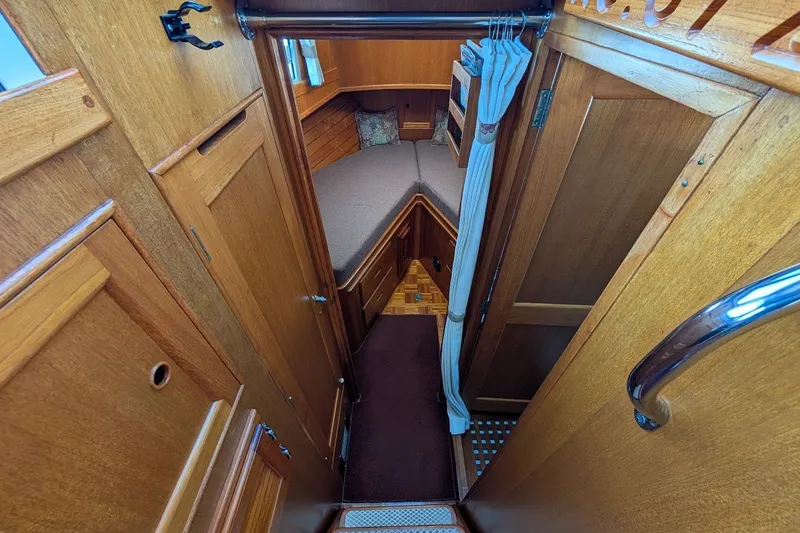 Slide: The Image of Cozy cabin interior of 1987 Island Gypsy 32 boat with wooden finish and compact bed. - 11