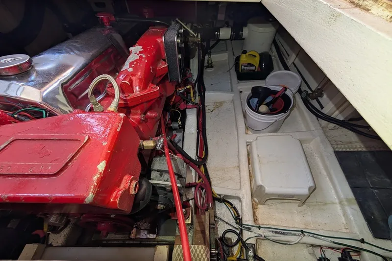 Slide: The Image of Engine room of a 1987 Island Gypsy 32 boat with red engine components and maintenance supplies. - 38