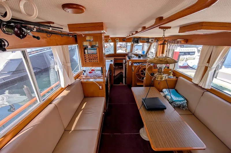 Slide: The Image of Interior of 1987 Island Gypsy 32 boat with cozy seating and nautical decor. - 15