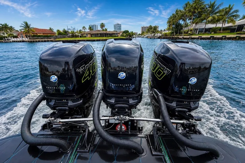 Slide: The Image of Triple outboard engines on a 2017 Statement 380 Open boat cruising in a scenic waterway. - 16