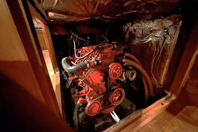 Slide: The Image of Engine compartment of a 1986 Passport 40 sailboat, showcasing mechanical components and hoses. - 17