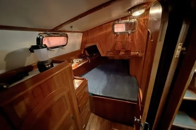 Slide: The Image of Cozy cabin interior of a 1986 Passport 40 sailboat with wooden furnishings. - 13