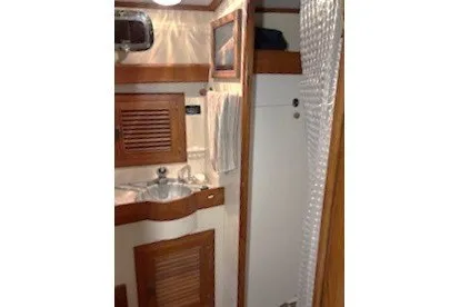 Slide: The Image of 1983 Passport 40 yacht bathroom with wooden cabinetry and sink. - 14