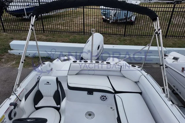 Slide: The Image of The image shows the cockpit of a Stingray 20 SC boat with white seating and a black bimini top. - 13