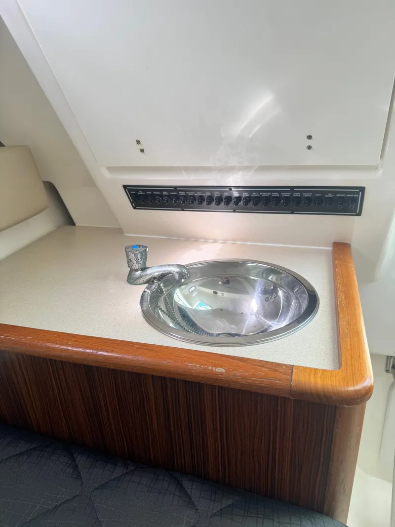 Slide: The Image of A sleek sink with wood trim and a control panel above, inside a boat. - 17