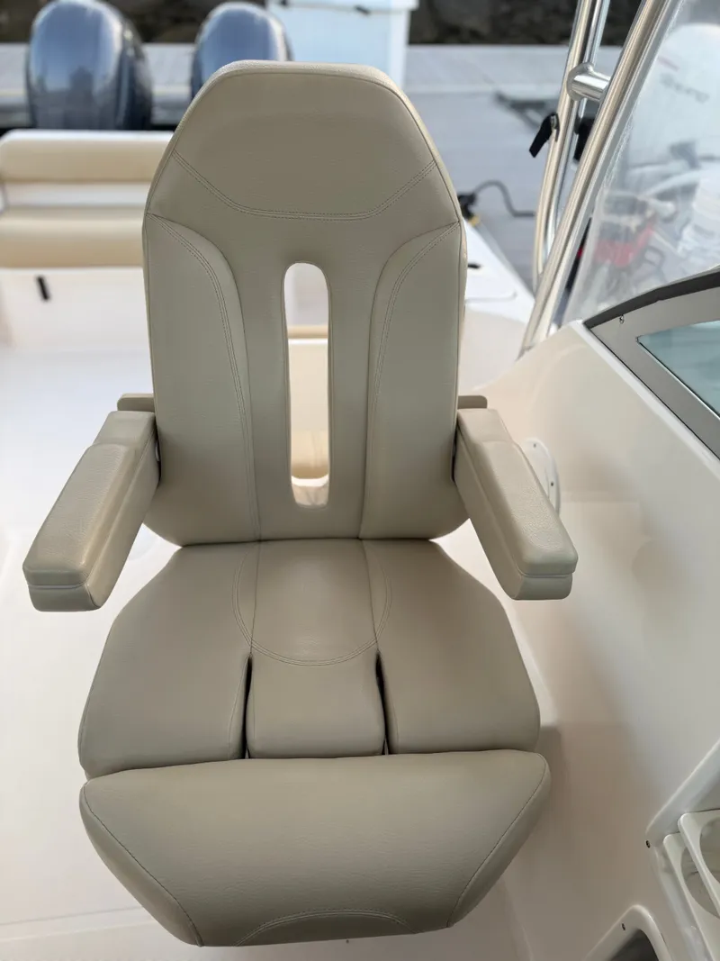 Slide: The Image of A beige captain's chair with armrests on a 2016 Pursuit OS 255 Offshore boat. - 11