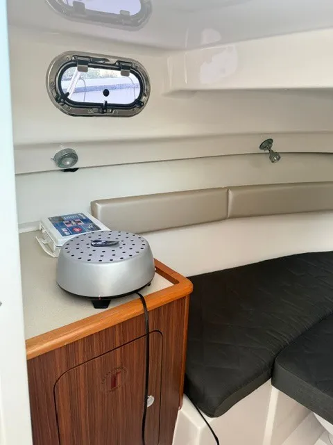 Slide: The Image of Interior of a 2016 Pursuit OS 255 Offshore with cushioned seating and a small table. - 15