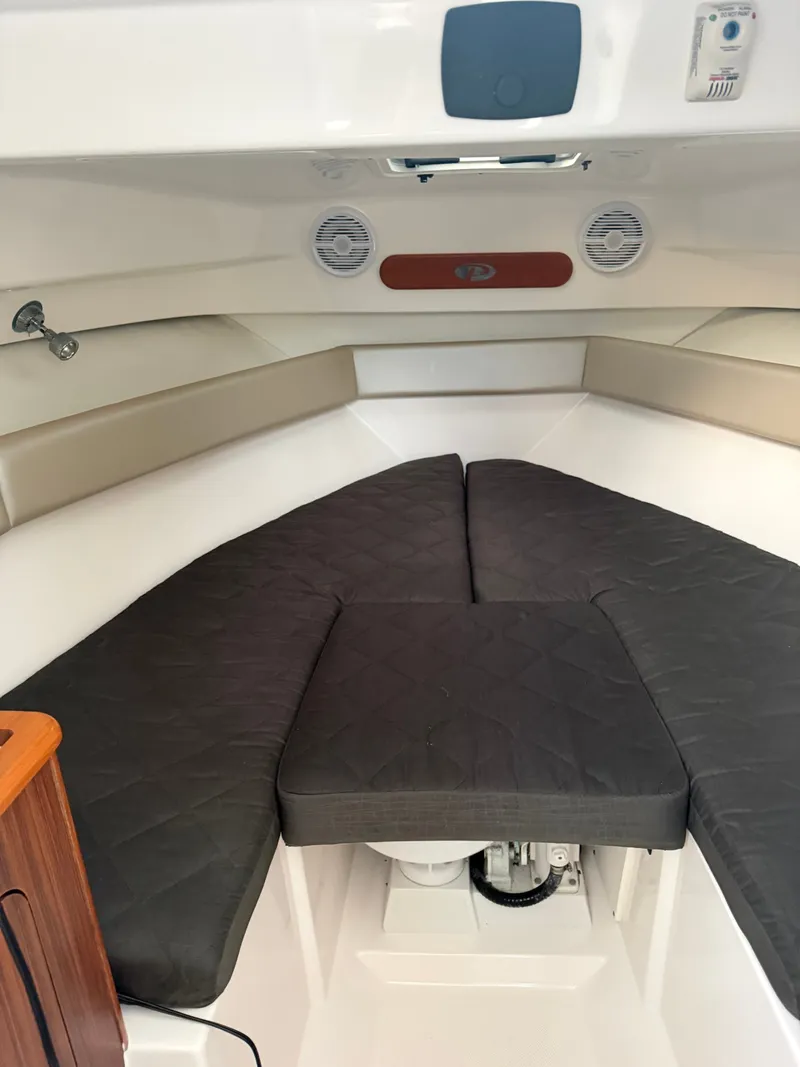Slide: The Image of Interior view of a 2016 Pursuit OS 255 Offshore with cushioned seating and wood accents. - 14
