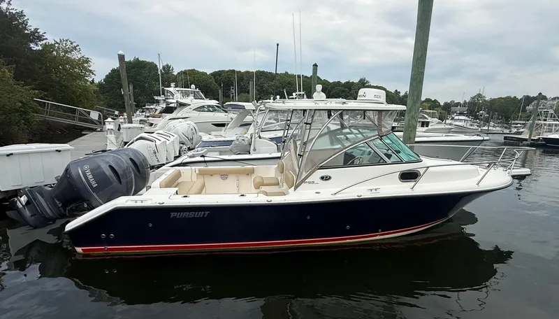 The Image of A 2016 Pursuit OS 255 Offshore boat docked in the water, surrounded by other boats. - 1