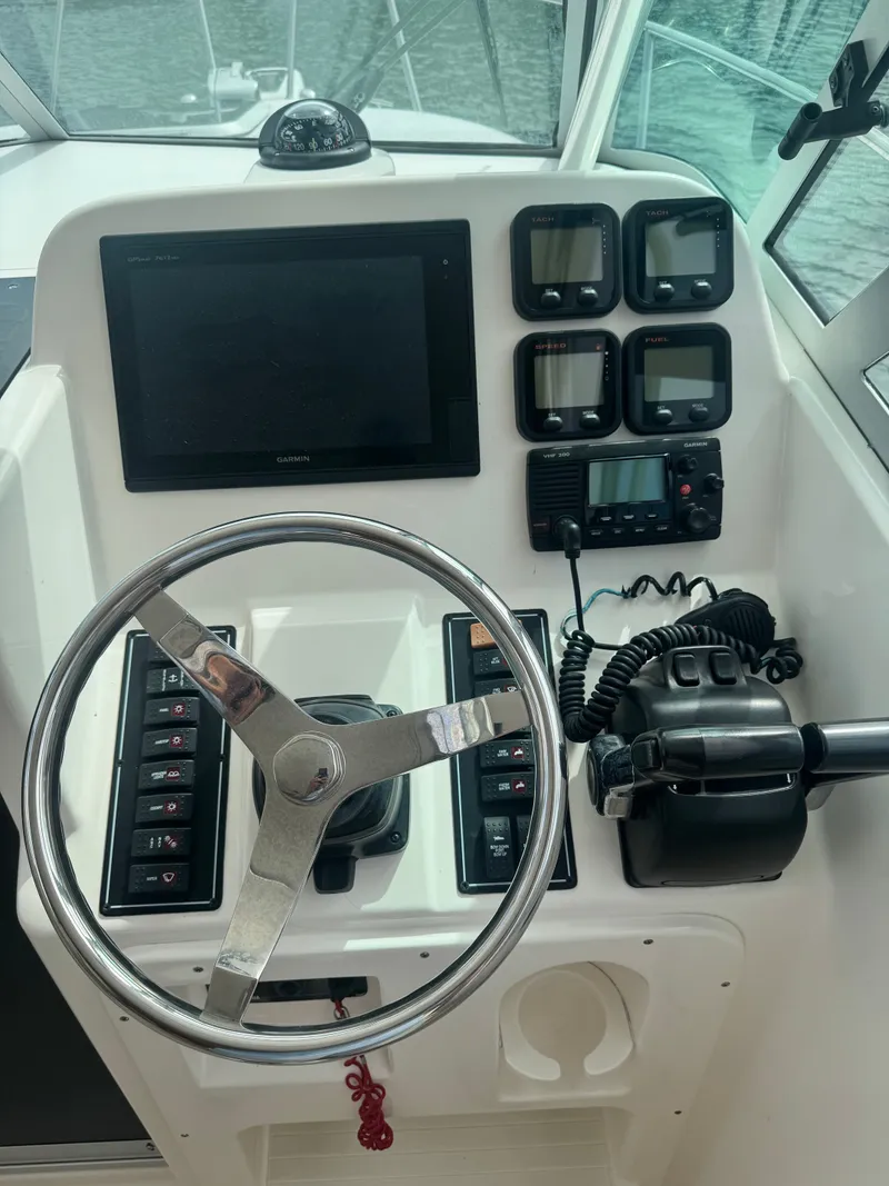 Slide: The Image of The image shows the helm of a 2016 Pursuit OS 255 Offshore boat with modern instruments. - 8