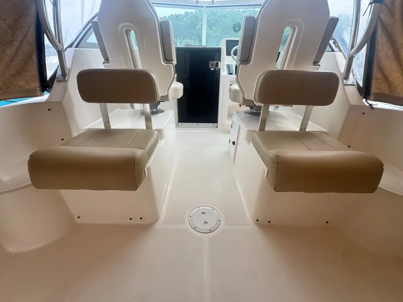 Slide: The Image of Interior view of a 2016 Pursuit OS 255 Offshore with two cushioned seats. - 10