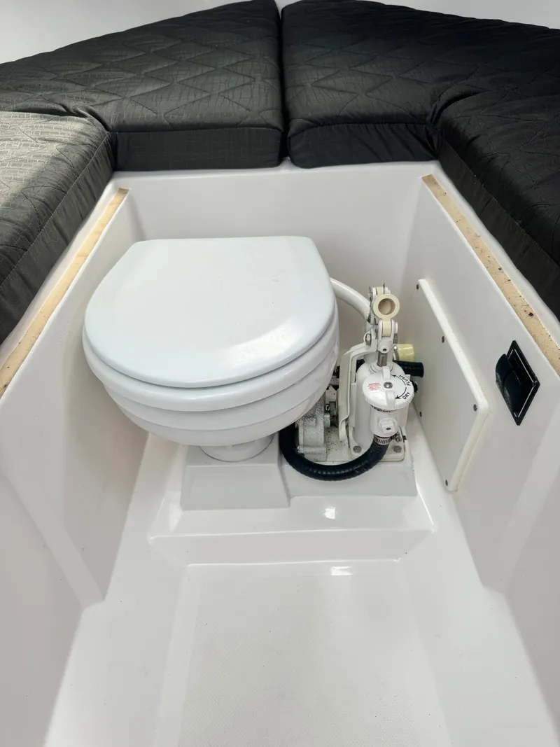 Slide: The Image of The image shows a toilet in the cabin of a 2016 Pursuit OS 255 Offshore boat. - 18