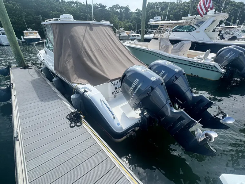 Slide: The Image of A 2016 Pursuit OS 255 Offshore docked. It features twin Yamaha outboard engines. - 5
